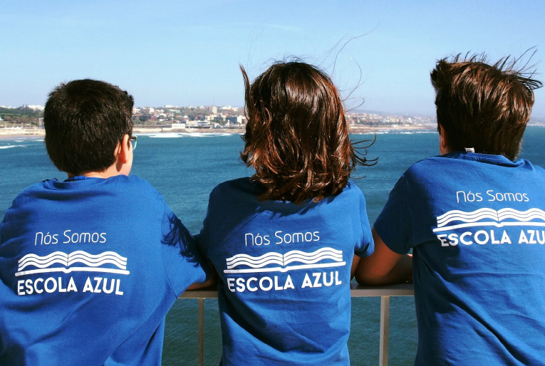 crianças num barco a olhar para o mar