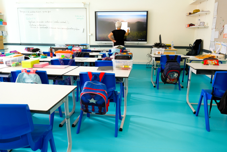 Sala de aula com a professora a utilizar um quadro digital